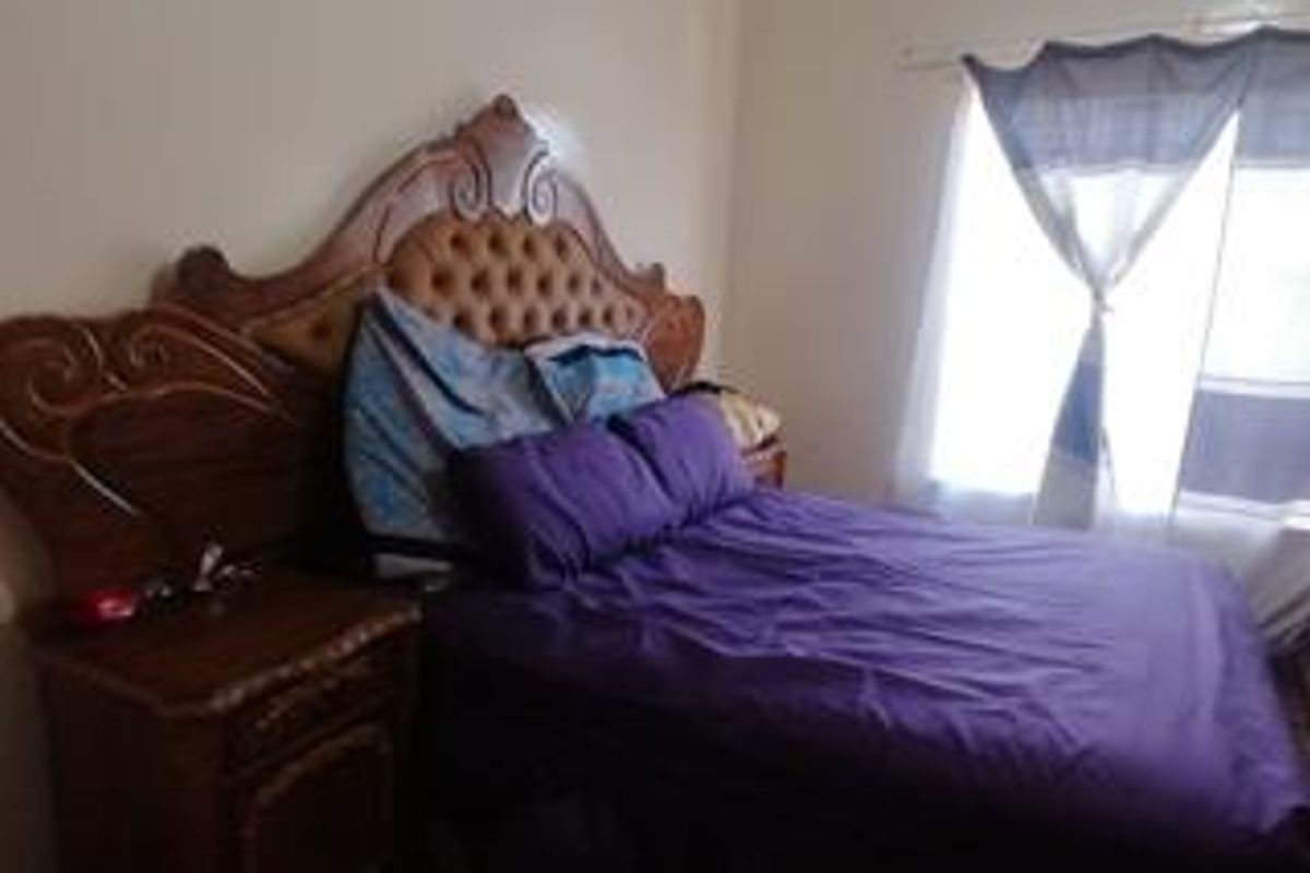A bedroom featuring neutral wall finishes and natural light from the window.