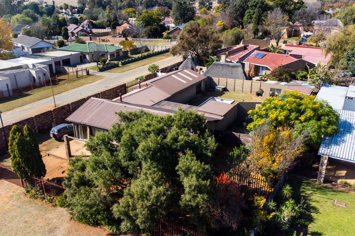 Aerial view of the residential property showing the roof structure, swimming pool, garden area, and surrounding neighbourhood context.