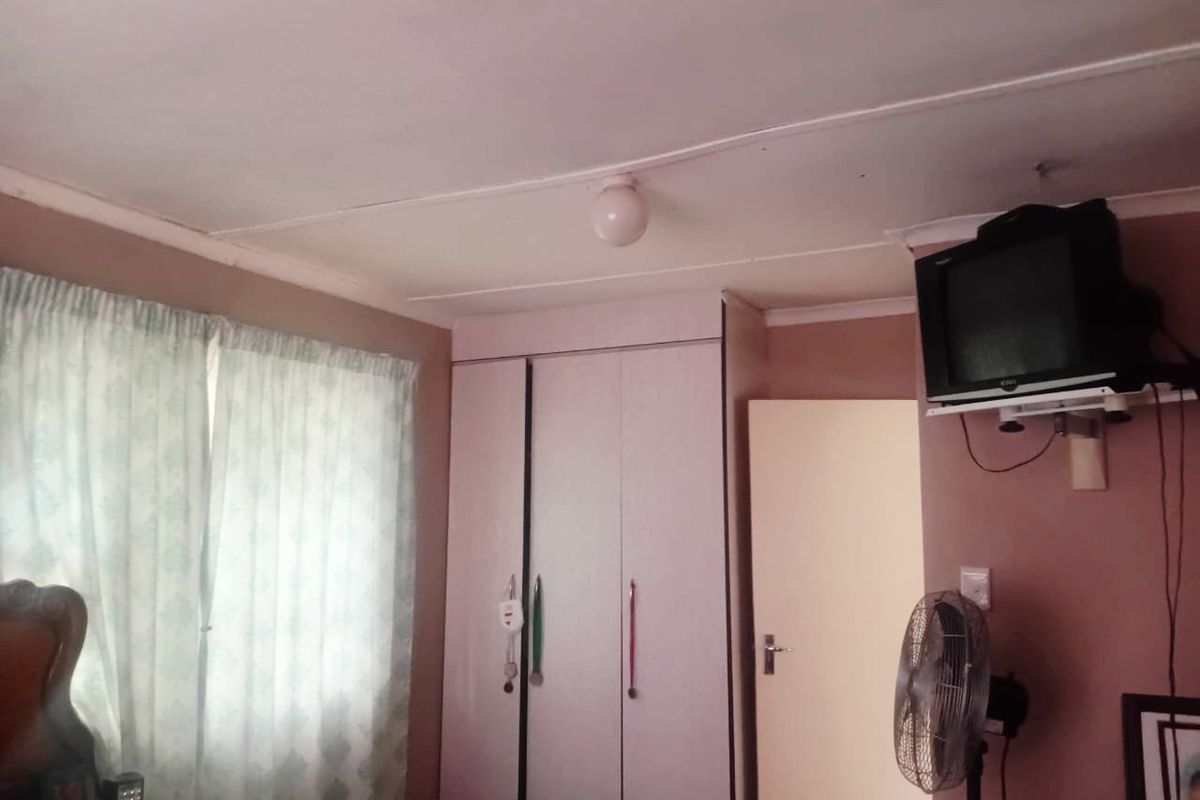 A bedroom featuring a built-in wardrobe and standard finishes, providing a functional sleeping space with basic infrastructure.