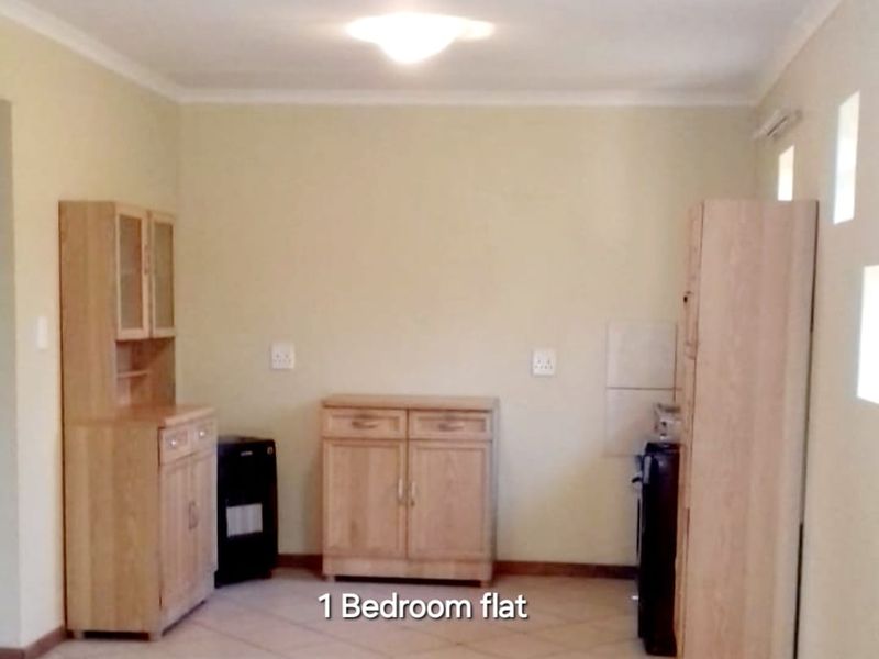 An open-plan living area featuring tiled flooring and neutral wall finishes, suitable for a combined lounge and dining space.