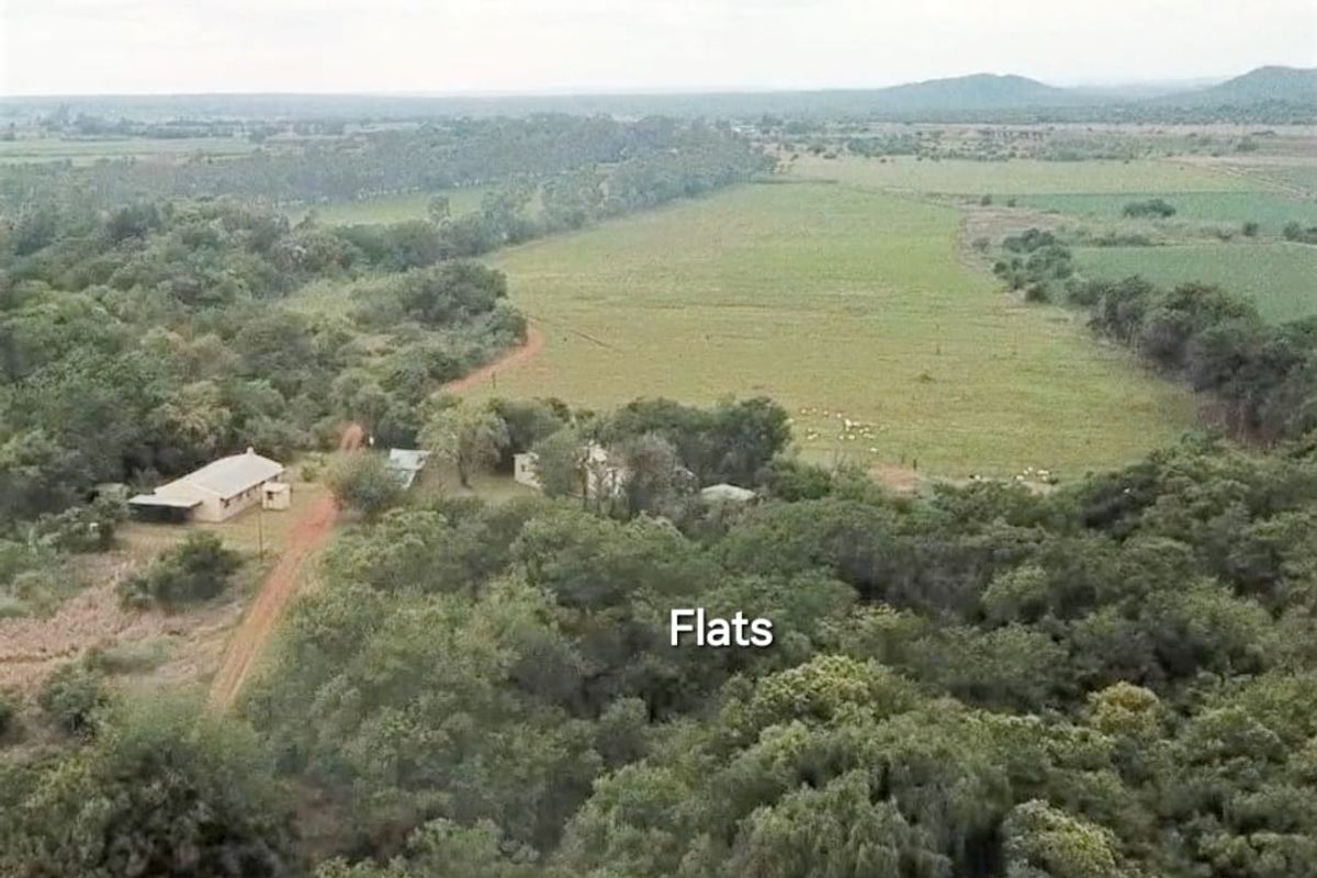 Aerial view of the farm property featuring expansive open fields, natural vegetation, and existing farm buildings set within a rural landscape.