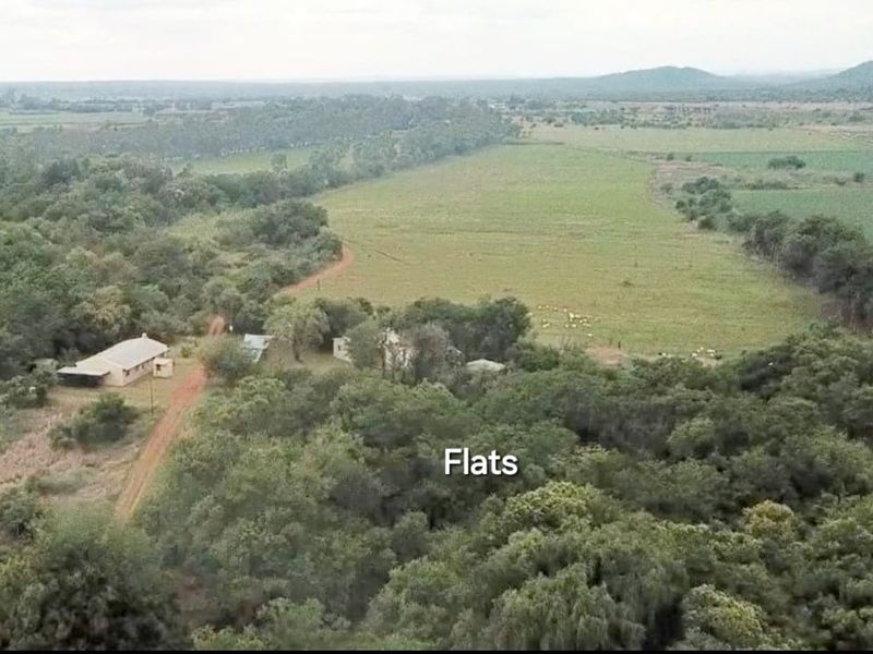 Aerial view of the farm property featuring expansive open fields, natural vegetation, and existing farm buildings set within a rural landscape.