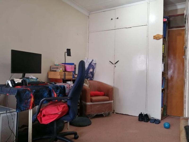 A bedroom featuring a built-in wardrobe, coving, and carpeted flooring, offering a functional space with potential for cosmetic updates.