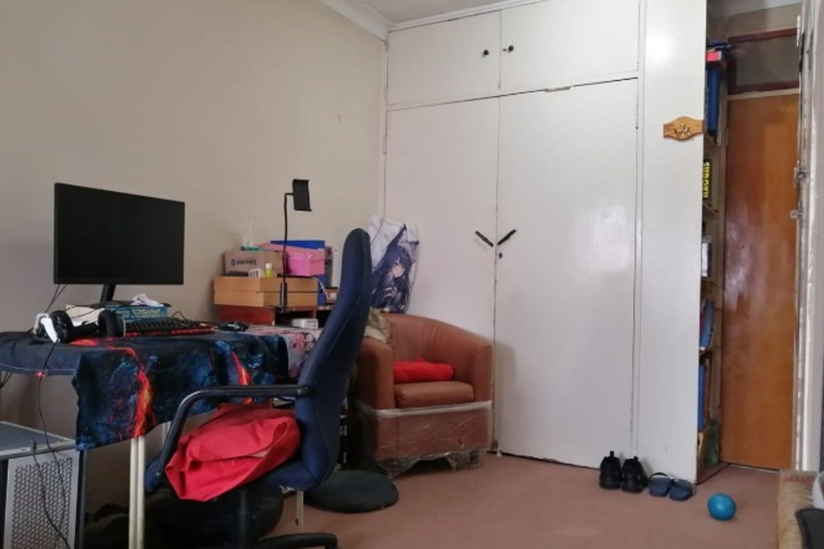 A bedroom featuring a built-in wardrobe, coving, and carpeted flooring, offering a functional space with potential for cosmetic updates.