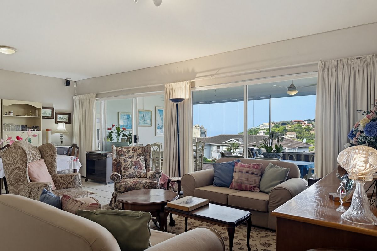 Spacious living room featuring large sliding glass doors that provide natural light and access to an outdoor balcony with scenic views.