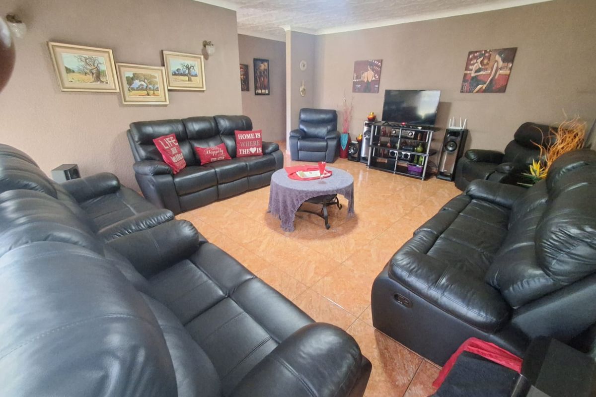 A spacious living room featuring tiled flooring and neutral wall tones, providing a comfortable area for relaxation and family gatherings.