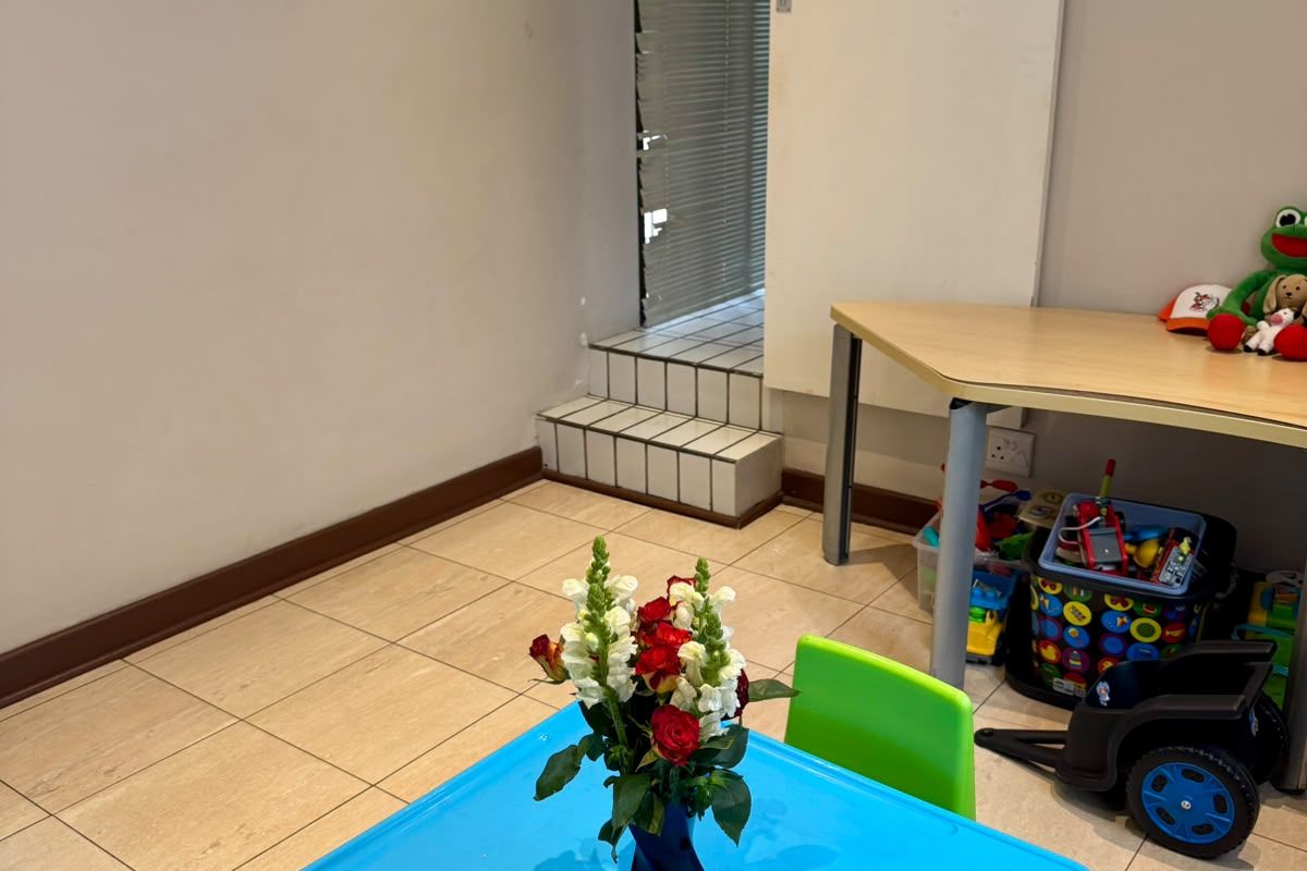 A multi-purpose room featuring tiled flooring and a sliding door leading to an elevated tiled step area.