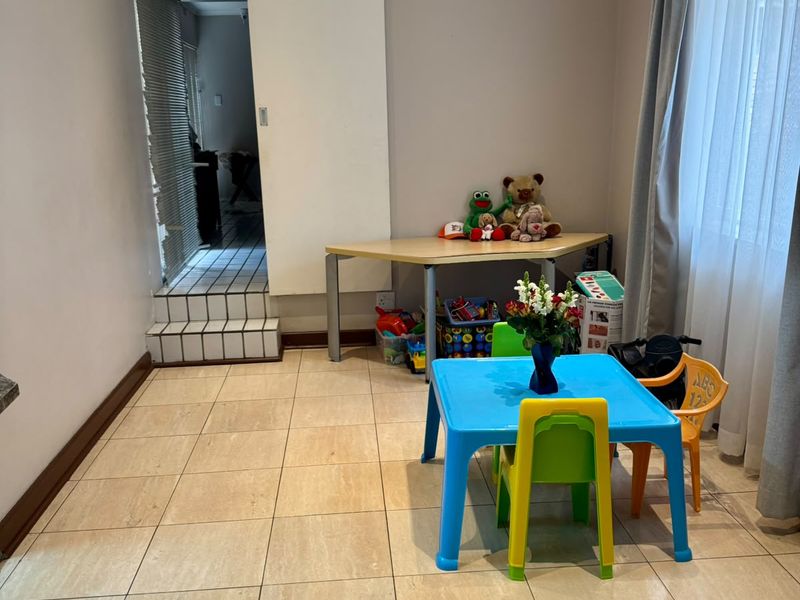 A functional living space featuring neutral wall tones, tiled flooring, and a sliding door leading to an adjacent tiled area.