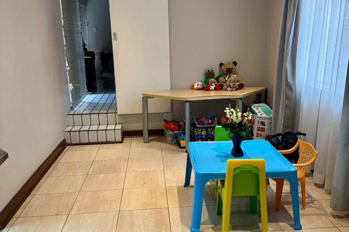 A functional living space featuring neutral wall tones, tiled flooring, and a sliding door leading to an adjacent tiled area.