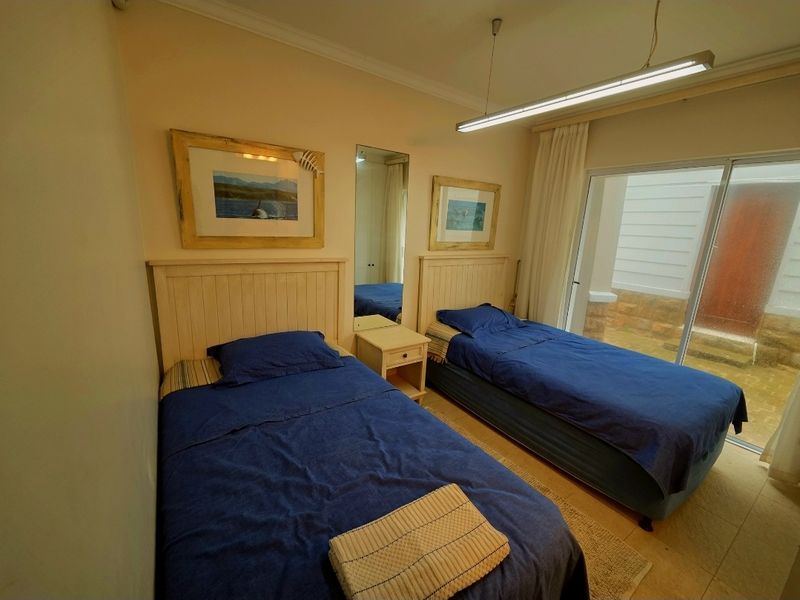 A bedroom featuring tiled flooring, built-in headboards, and sliding glass doors providing direct access to an outdoor area.