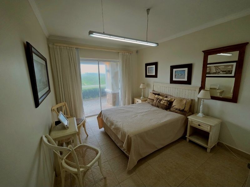 A bedroom featuring tiled flooring, a sliding glass door leading to a private balcony, and built-in ceiling lighting.