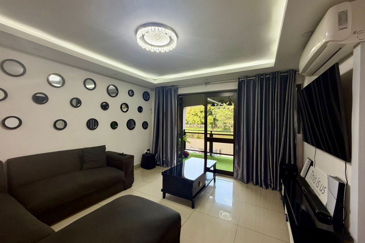 Modern living room featuring tiled flooring, recessed ceiling lighting, and a wall-mounted air conditioning unit, with direct access to a private balcony.
