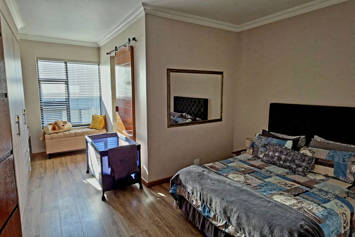 A well-maintained bedroom featuring wood-look flooring, built-in cabinetry, and a sliding barn-style door leading to an adjacent space.