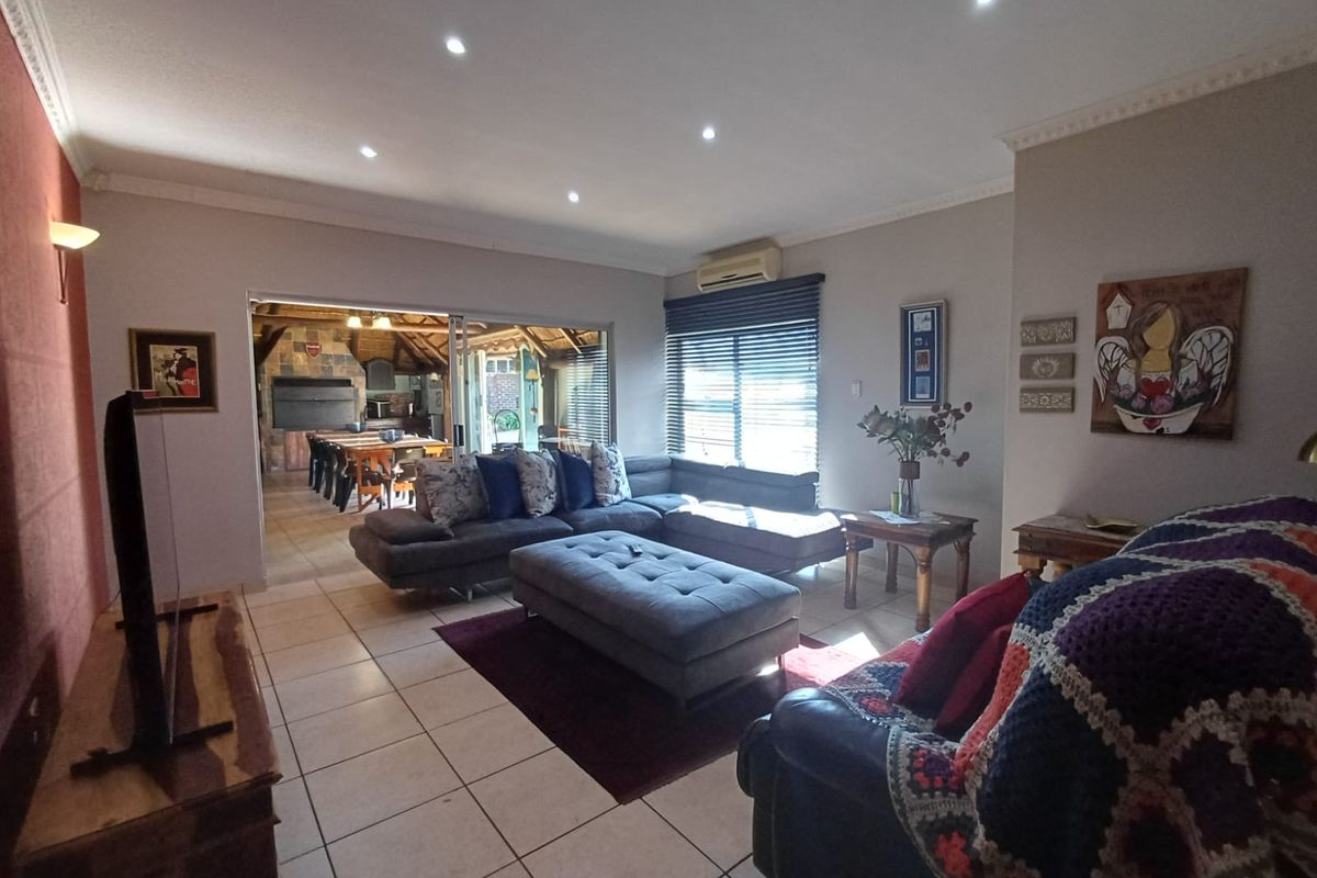 Spacious living room featuring tiled flooring, recessed downlighting, and sliding glass doors providing seamless access to an outdoor entertainment area.