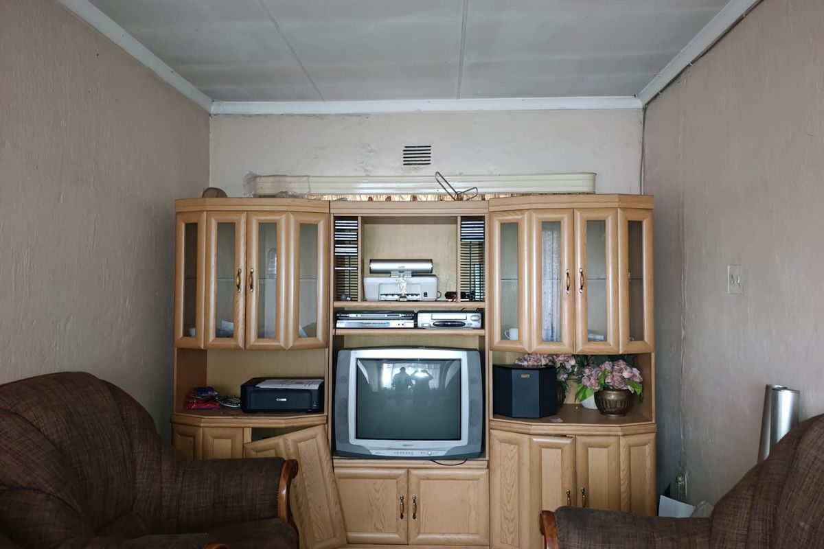 A living room featuring a built-in wooden wall unit and neutral wall finishes.