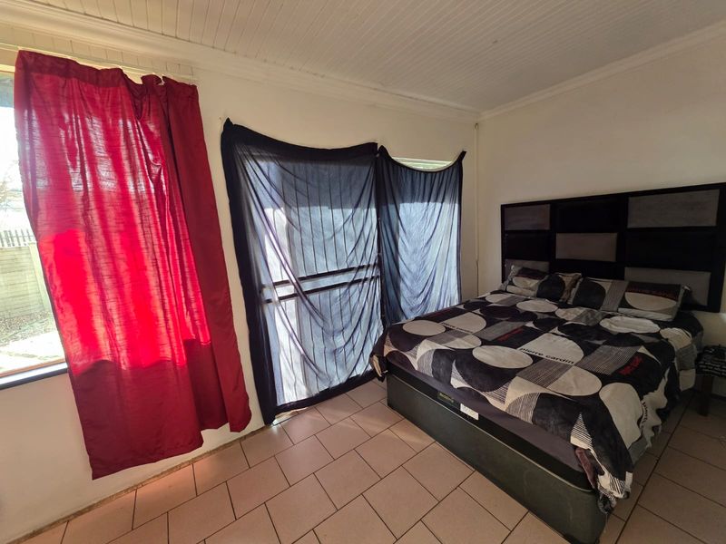 A bedroom featuring tiled flooring, a beadboard ceiling, and sliding door access to the exterior.