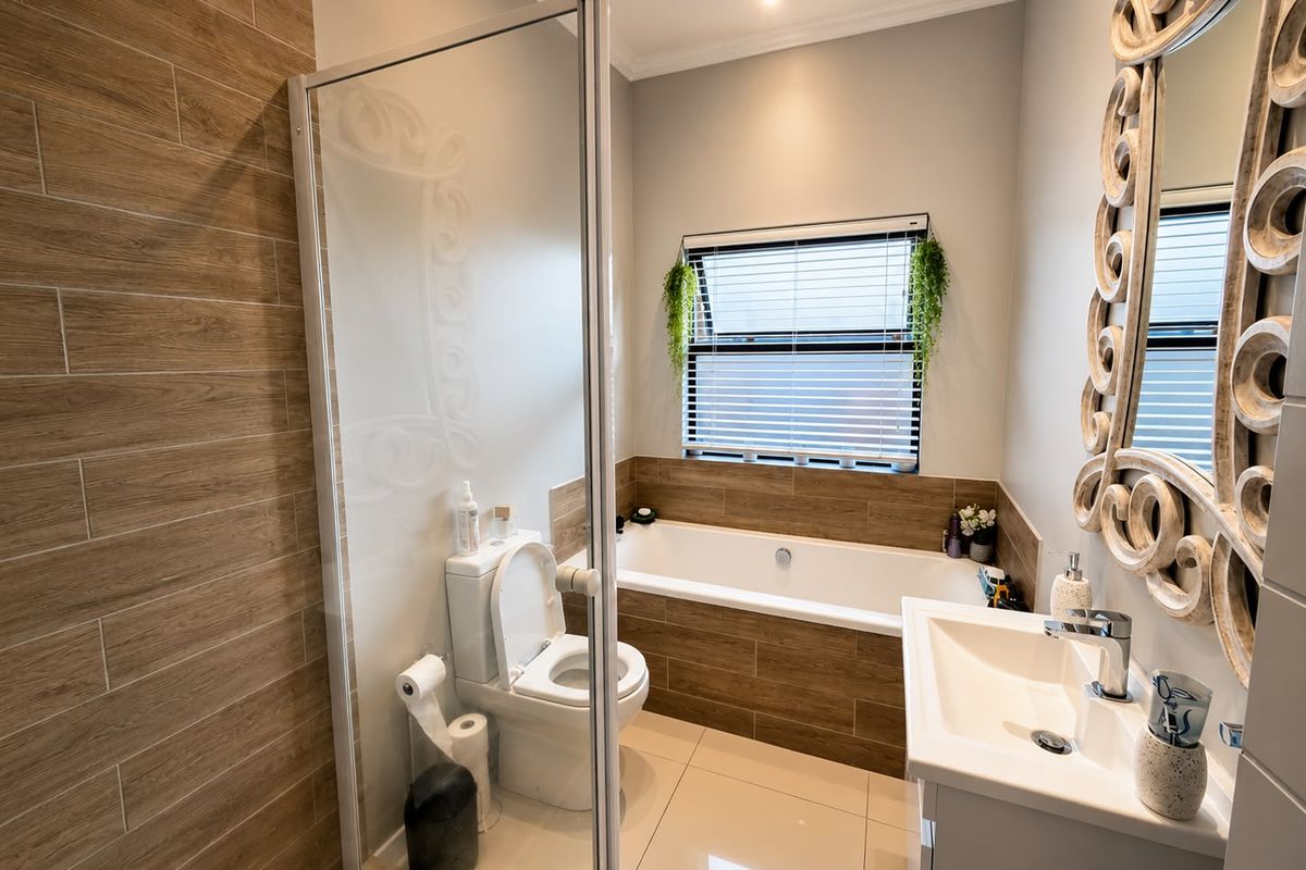 Modern bathroom featuring a built-in bathtub, glass-enclosed shower, vanity basin, and contemporary wood-look wall tiling.