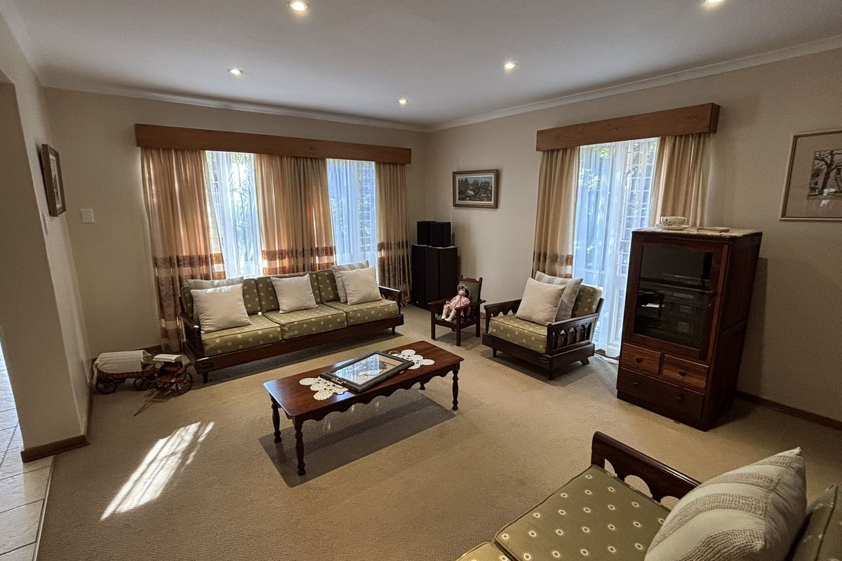 Spacious living room featuring neutral carpeting, recessed downlighting, and large sliding glass doors providing natural light.