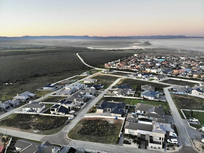 Aerial view of a residential estate development showing paved streets, established housing, and surrounding natural landscape.