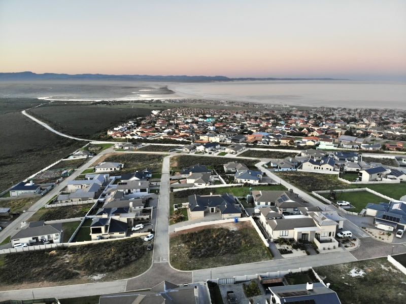 An aerial view of a residential neighborhood and surrounding coastal landscape, showcasing the property's location within the established community.