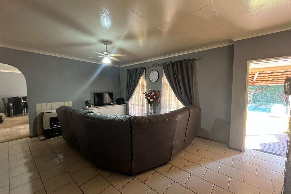 Spacious living room featuring tiled flooring, a built-in fireplace, and direct access to the outdoor pool area.