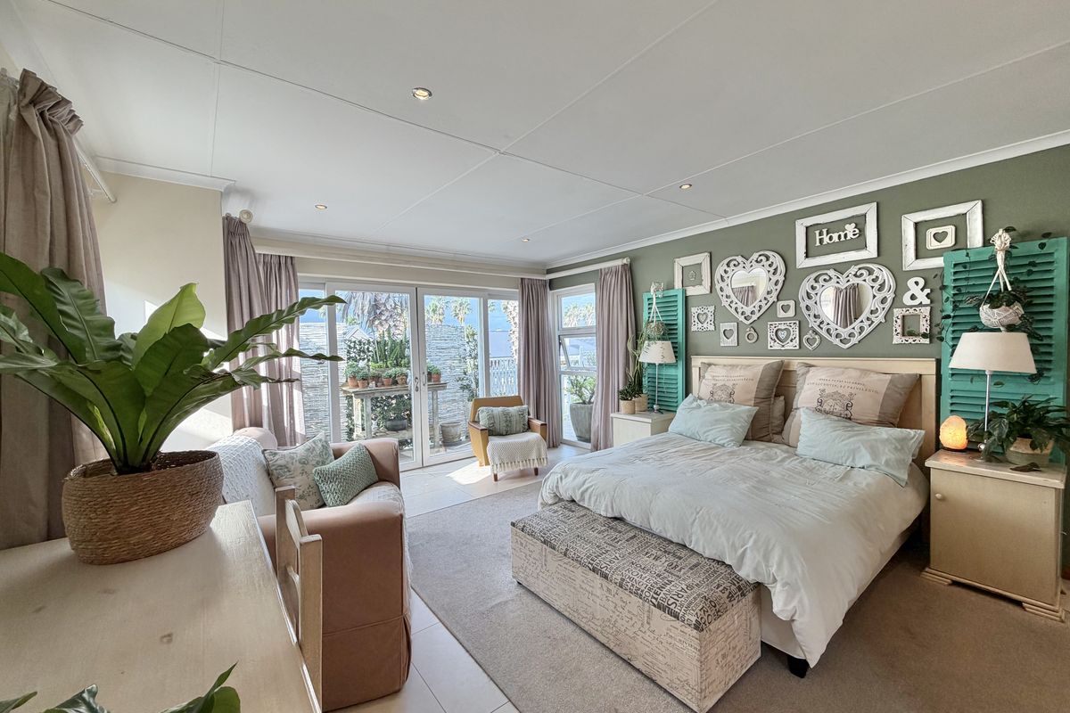 Spacious bedroom featuring tiled flooring, recessed lighting, and large sliding glass doors providing direct access to an outdoor patio area.