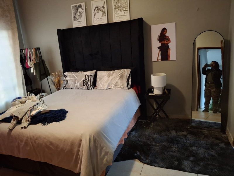 A bedroom featuring tiled flooring and neutral wall finishes, providing a functional space for rest.