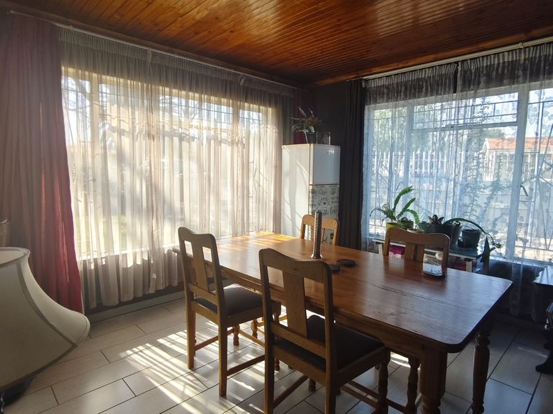Dining room featuring tiled flooring and a warm timber tongue and groove ceiling, providing a classic aesthetic with ample natural light.