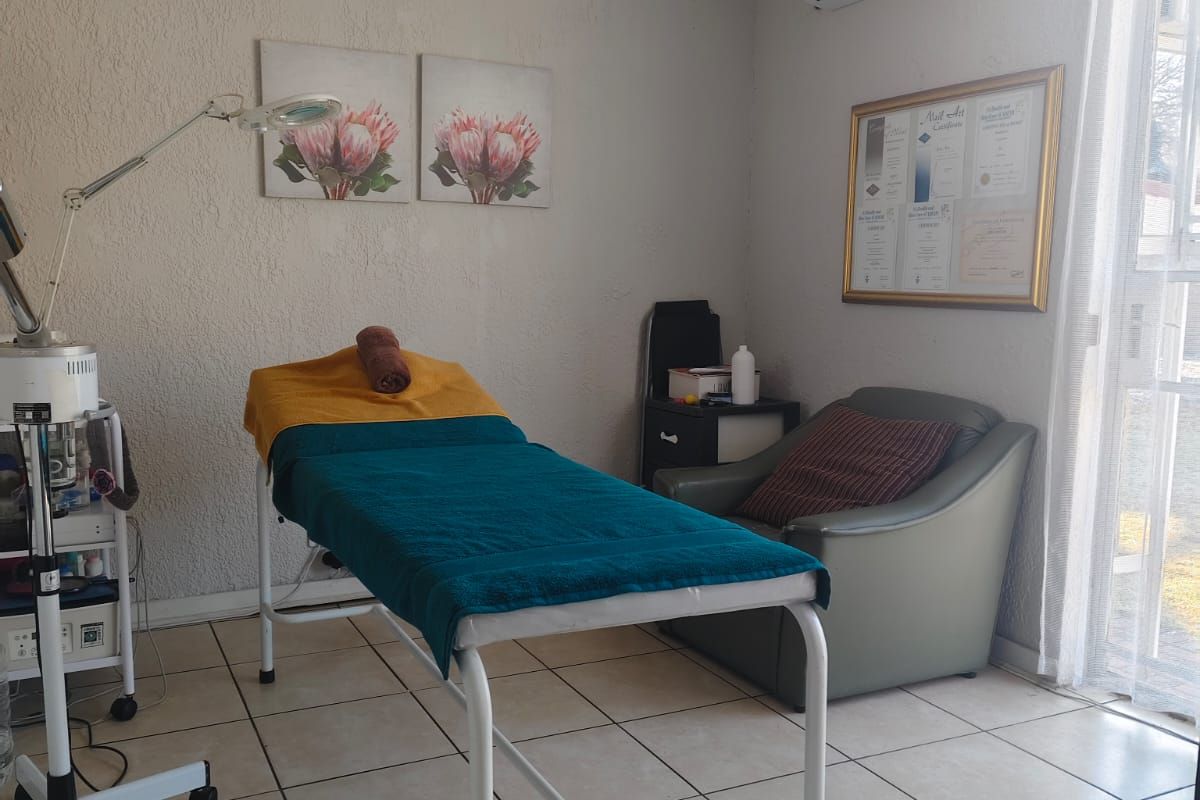 A functional room currently utilized as a treatment space, featuring tiled flooring, a ceiling fan, and a wall-mounted air conditioning unit.