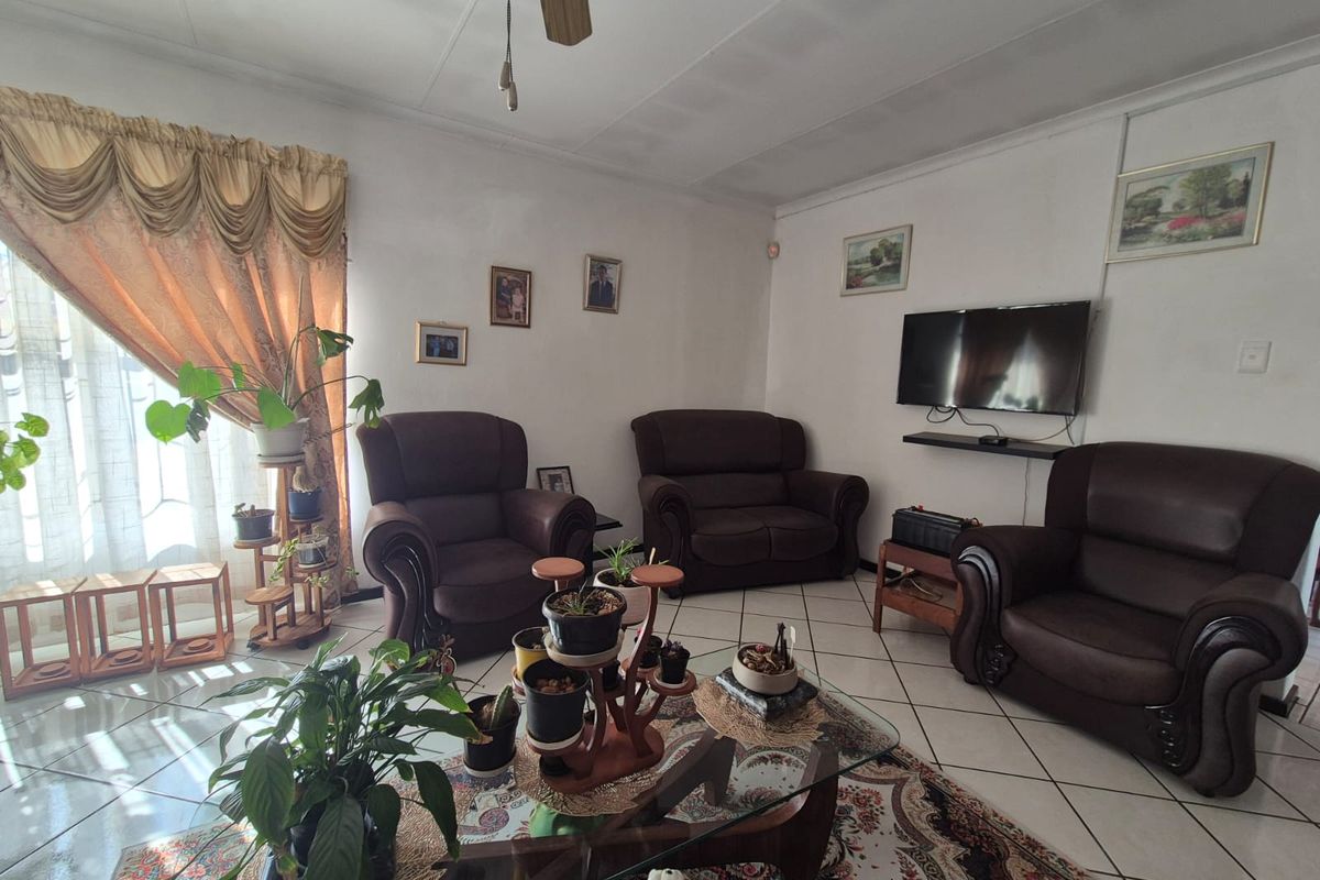 A living room featuring ceramic floor tiles and a ceiling fan, providing a functional and comfortable space for relaxation.