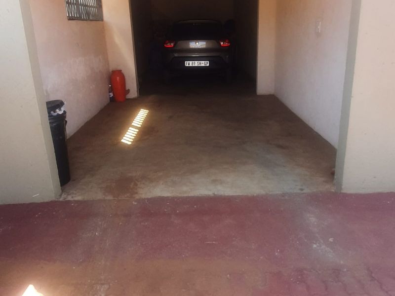 A functional single-car garage featuring a concrete floor and side ventilation window, providing secure off-street parking space.