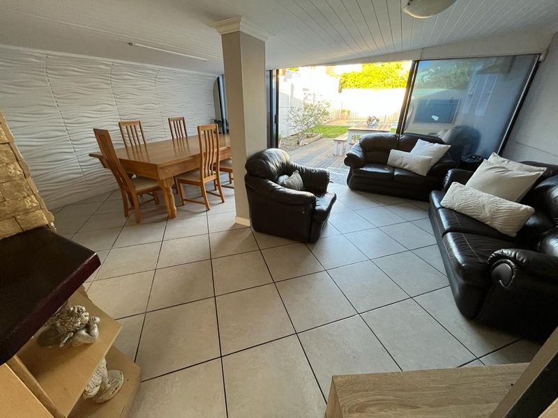 Open plan living and dining area featuring large sliding glass doors that provide seamless access to the rear patio and garden.