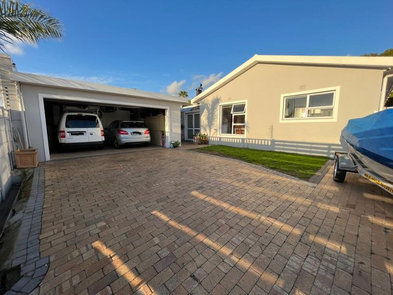 Front exterior view of the property featuring a paved driveway, double garage, and well-maintained rendered facade.