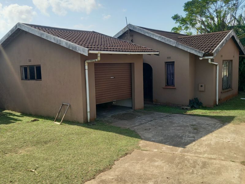 Front elevation of a single-story house featuring a concrete driveway, tiled roof, and an integrated garage with a roller door.