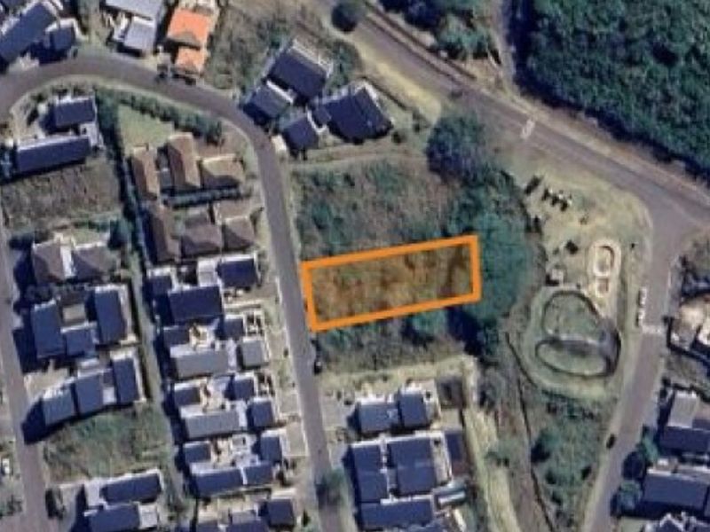 An aerial view of a vacant residential land plot situated within an established neighborhood.