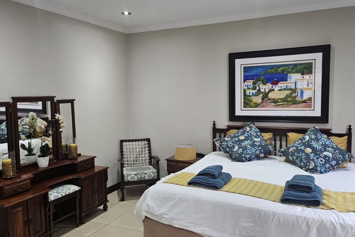 A well-maintained bedroom featuring neutral wall tones, tiled flooring, and recessed ceiling lighting, providing a comfortable and clean living space.