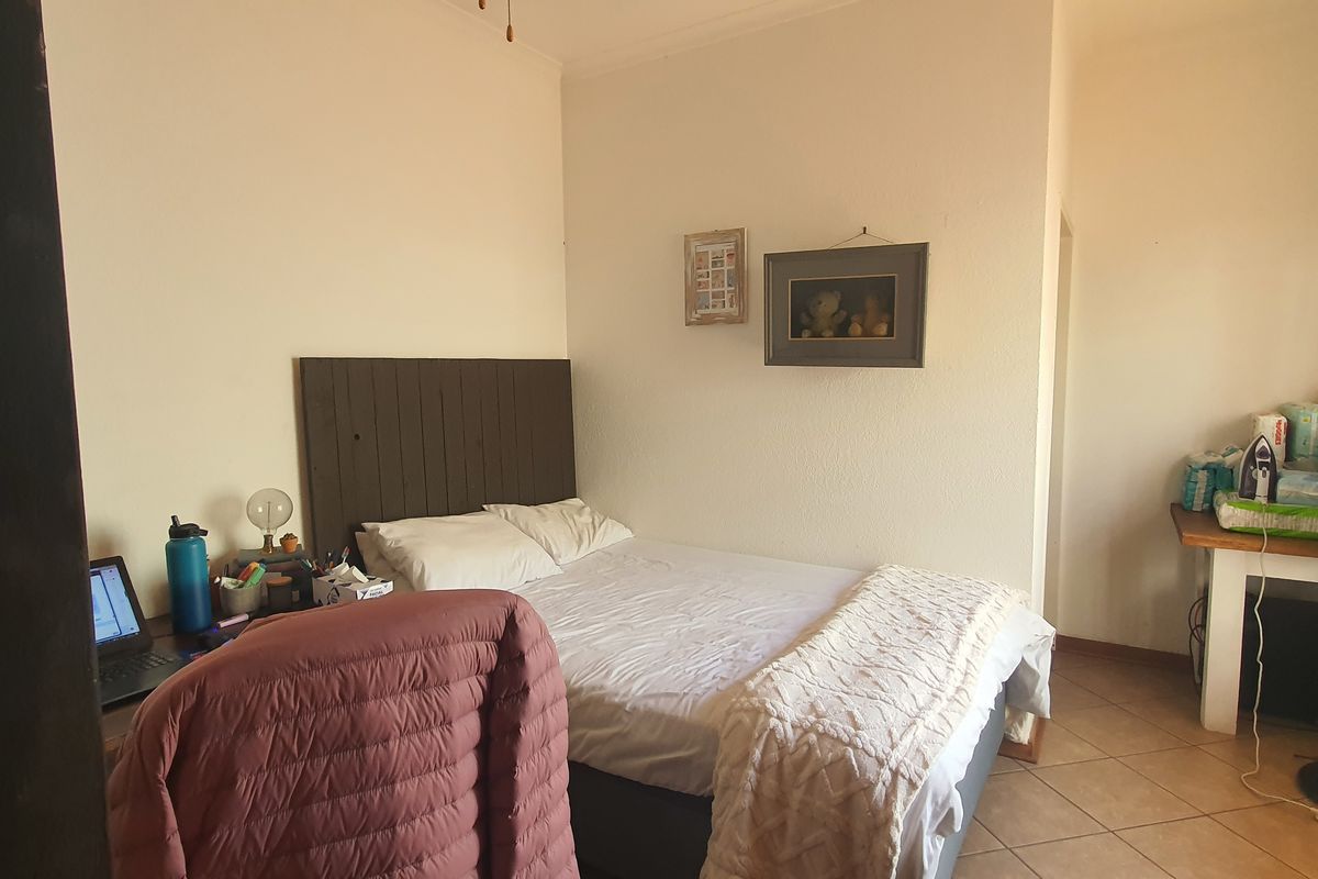 A functional bedroom featuring tiled flooring and a ceiling fan, offering a neutral space ready for personalization.