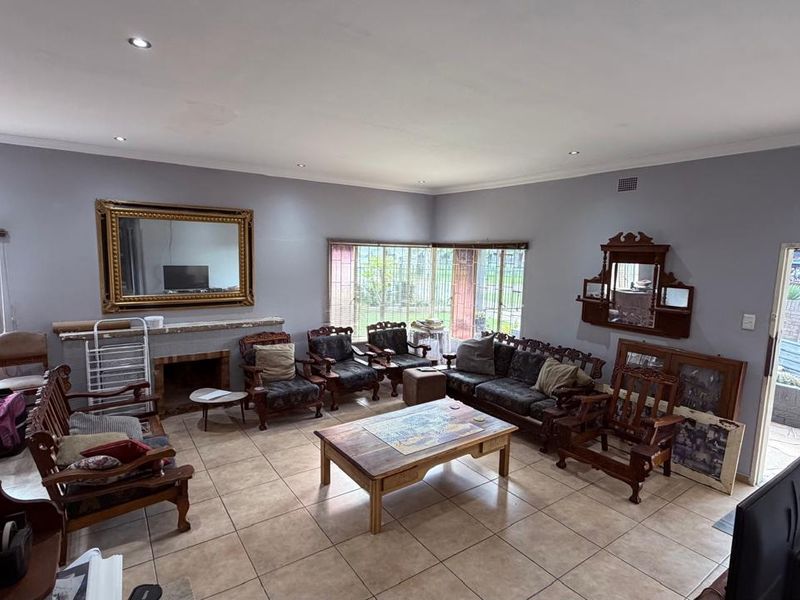 Spacious living room featuring tiled flooring, recessed downlighting, and a built-in fireplace, offering a comfortable and functional layout for family relaxation.