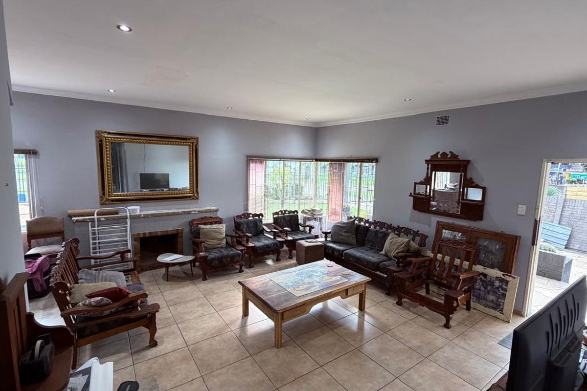 Spacious living room featuring tiled flooring, recessed downlighting, and a built-in fireplace, offering a comfortable and functional layout for family relaxation.