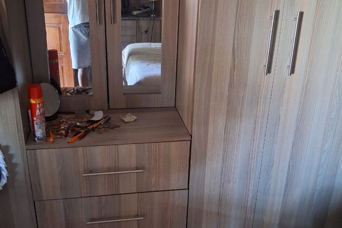 A bedroom featuring built-in wooden cabinetry with integrated wardrobe and vanity storage.