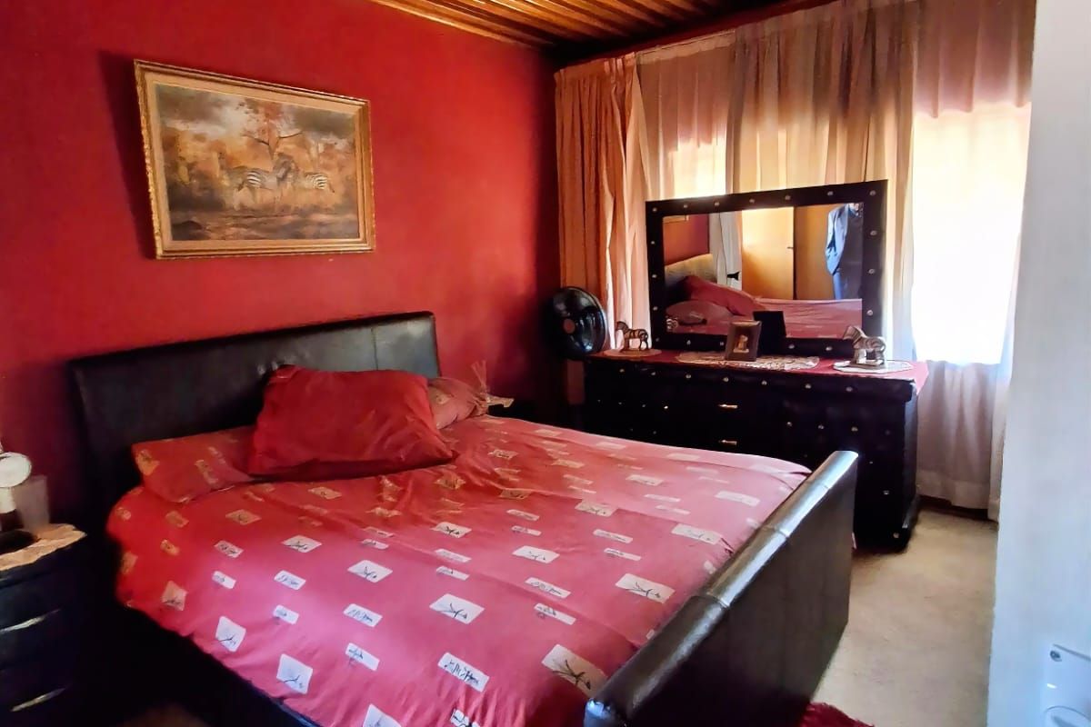 A bedroom featuring a timber-clad ceiling and a central ceiling fan, providing a traditional aesthetic.