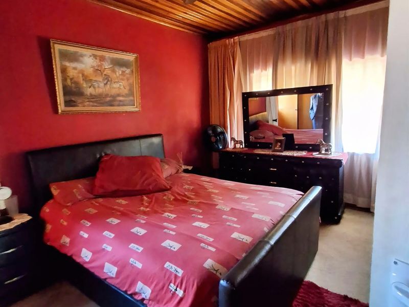 A bedroom featuring a timber-clad ceiling and a central ceiling fan, providing a traditional aesthetic.
