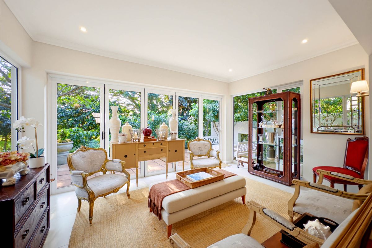 Bright and airy living room featuring large glass sliding doors that provide seamless access to the outdoor patio and garden area.