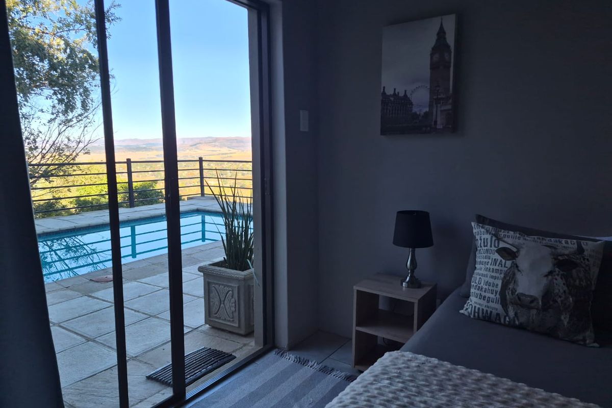 Bedroom featuring sliding glass doors that open onto a private patio with a swimming pool and scenic landscape views.