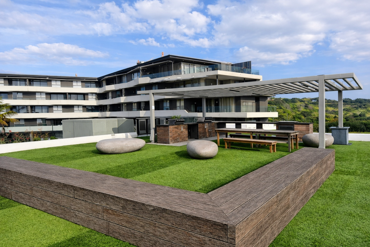 Spacious rooftop terrace featuring a modern pergola, built-in barbecue area, and artificial turf, offering an ideal outdoor entertainment space.