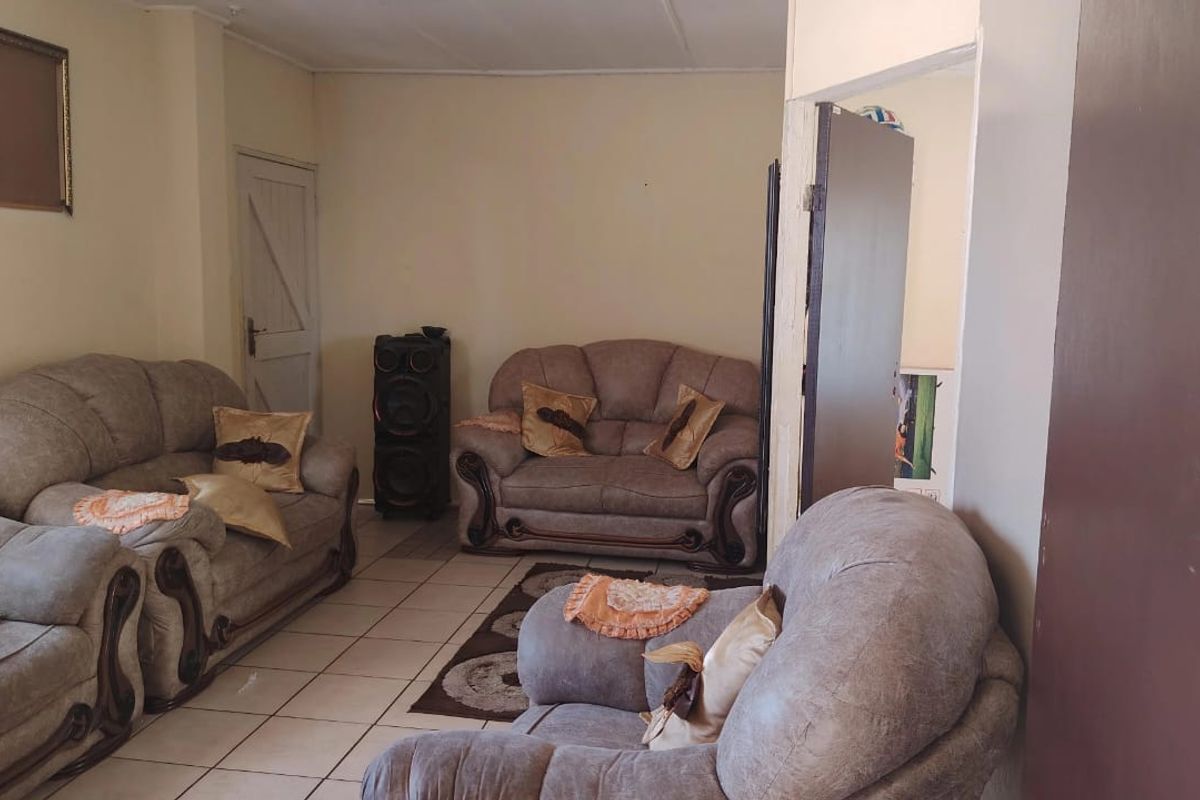 A living room area featuring tiled flooring and neutral wall finishes, providing a functional space for relaxation.