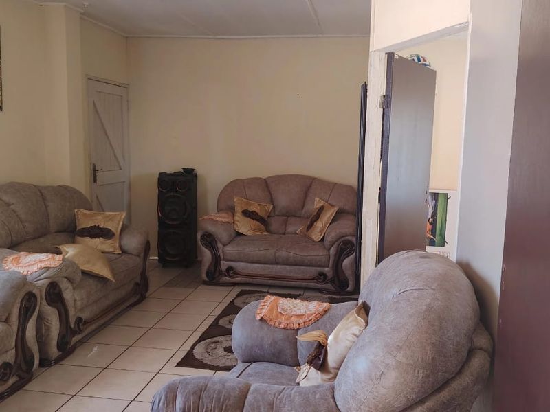 A living room area featuring tiled flooring and neutral wall finishes, providing a functional space for relaxation.