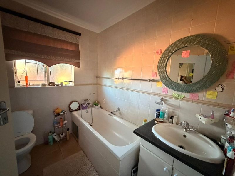 A functional bathroom featuring a built-in vanity with a basin, a standard bathtub, and tiled wall finishes.
