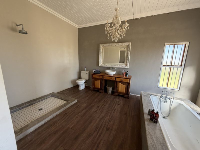 Spacious bathroom featuring a walk-in shower, built-in bathtub, and a vanity with a vessel sink, set against a neutral color palette.