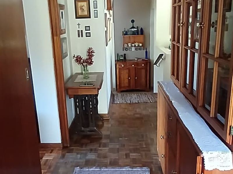 A traditional hallway featuring classic parquet flooring and extensive built-in wooden cabinetry, providing a warm and functional transition space within the home.
